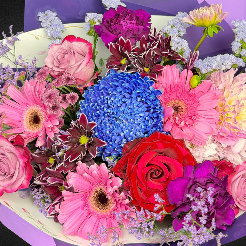 Close-up view of the fresh, premium Roses, Chrysanthemums, and Dahlias in the Mother's Day Radiance Bouquet, showcasing the intricate details and 'Mixed Brights' color palette.
