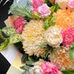 Close-up of a vibrant pastel Mother's Day bouquet featuring roses, chrysanthemums, and carnations.