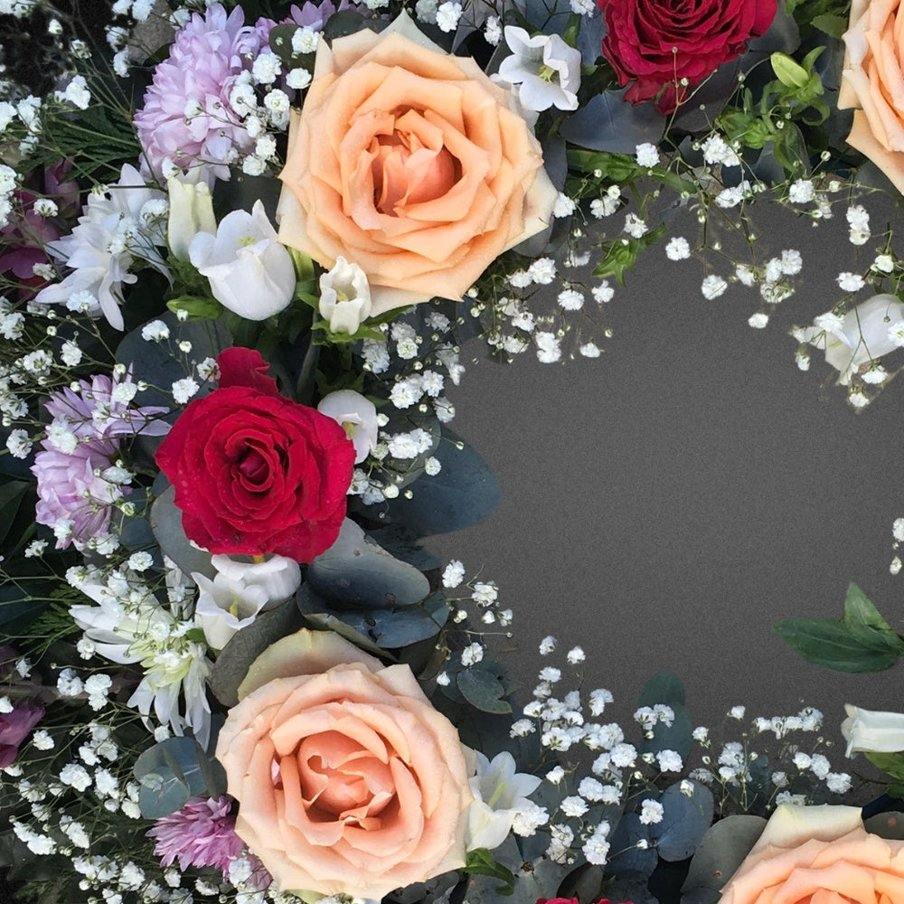 Close-up detail of the artisan craftsmanship of the FLOWER SHED Brisbane wreath, showcasing the realistic textures and bright colours of the faux rose, chrysanthemum, and lisianthus flowers.